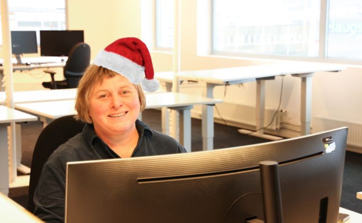 Department manager Solution Services, Siw Gjerdingen, sitting in front of a computer with a christmas hat